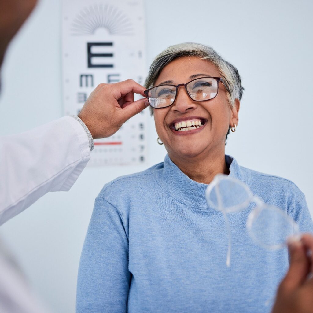 Lächelnde ältere Frau beim Sehtest beim Optiker