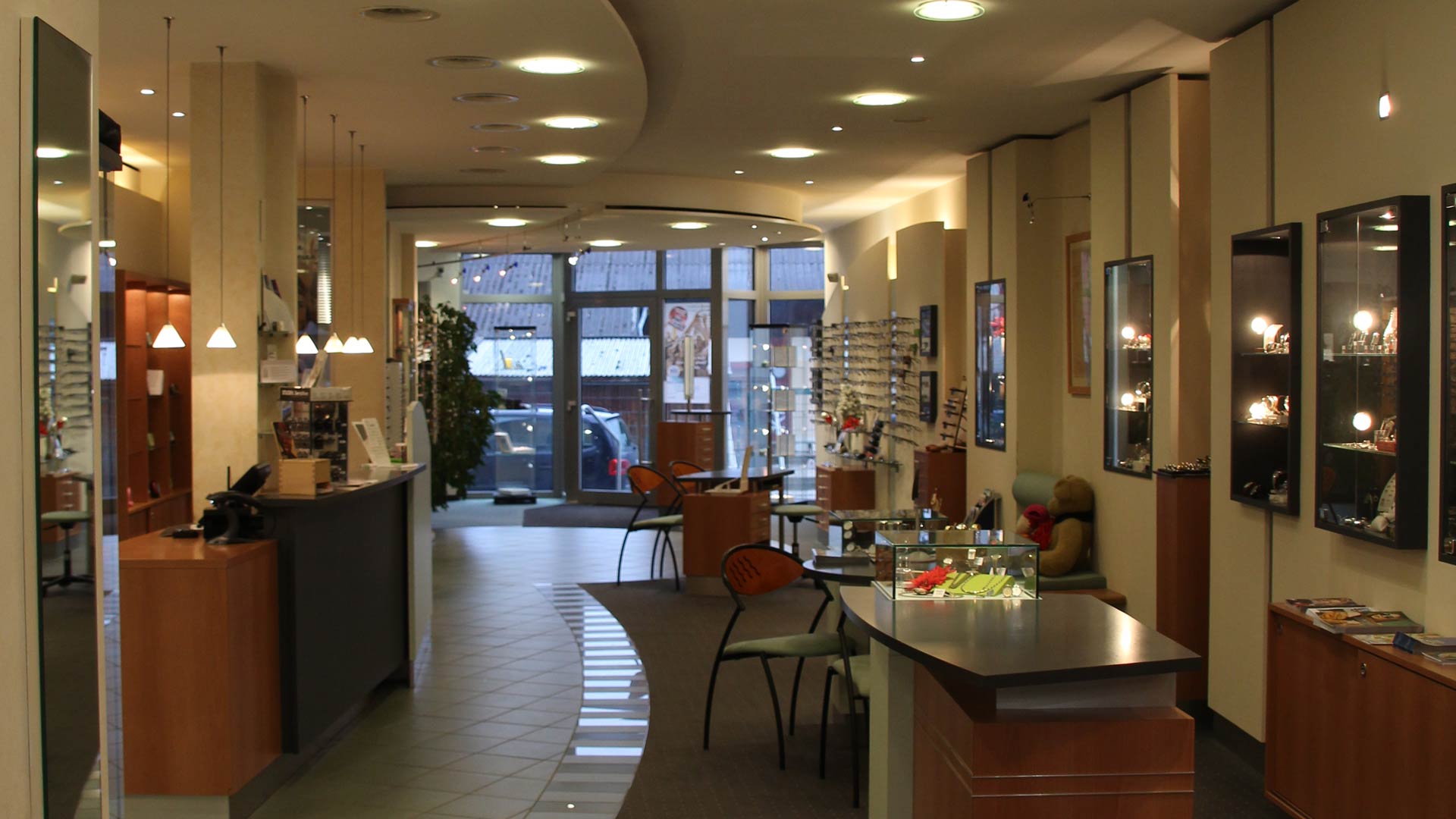 Ein modernes Optikgeschäft mit Brillen, Holzregalen und eleganter Beleuchtung.